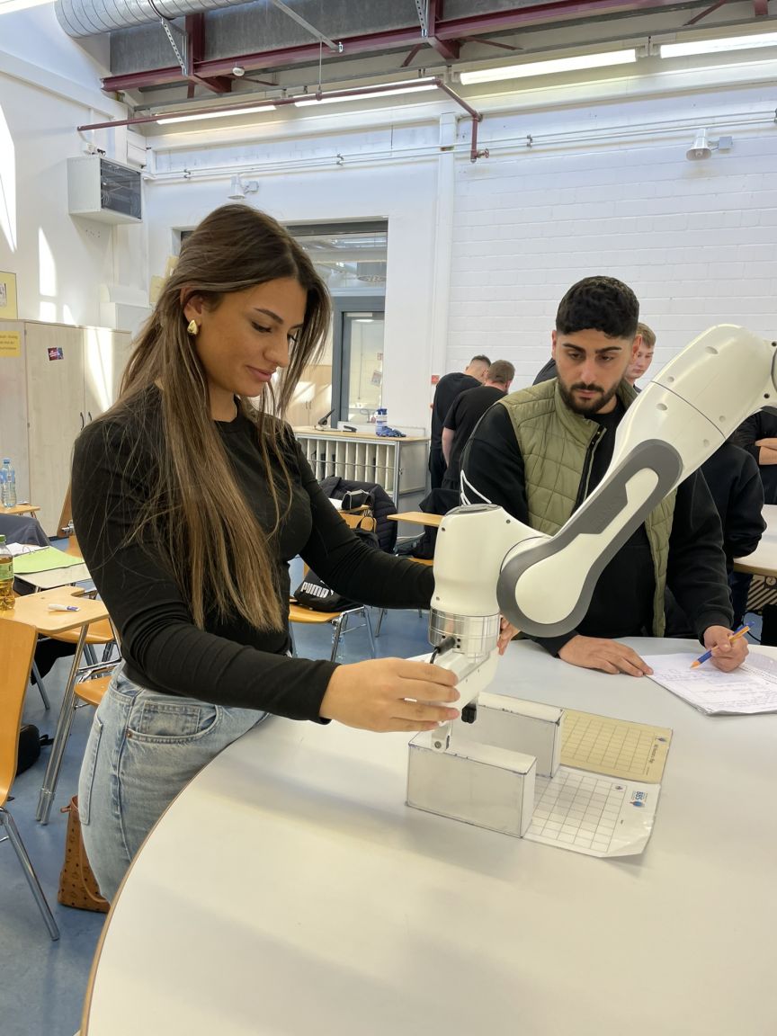 Schülerin forscht mit Roboterarm